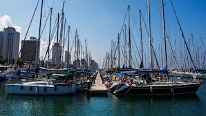 A marina with numerous sailboats docked in calm waters, surrounded by tall buildings. - Shalom Hotel & Relax - an Atlas Boutique Hotel (Tel Aviv)