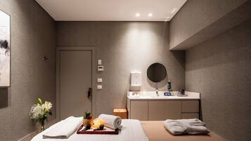 Una habitación de hotel moderna con una cama, una mesita de noche con lámpara, un espejo y un escritorio pequeño con cafetera.