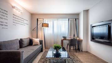 A modern living room with a sofa, coffee table, and a TV mounted on the wall.