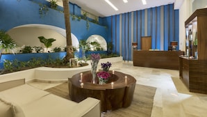 Eine moderne Lobby mit Empfangstresen, Sitzgelegenheiten und Zierpflanzen.