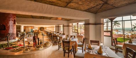 A restaurant with a rustic ceiling, a buffet with various dishes, and tables set for dining.