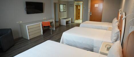 A hotel room with two beds, a desk, a chair, a television, and a wardrobe.