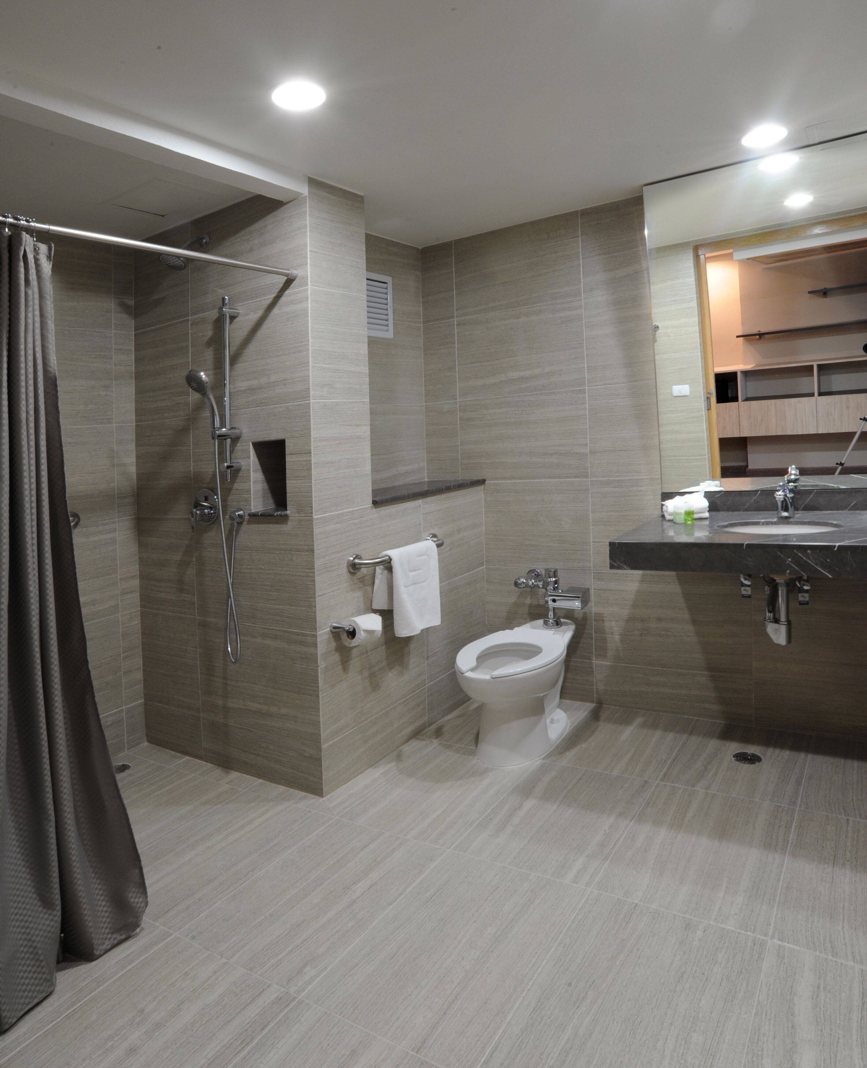 A modern bathroom with a shower, toilet, and sink.