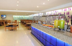 Ein Bereich mit Buffet, einer Theke, Stühlen und einem Fernseher.