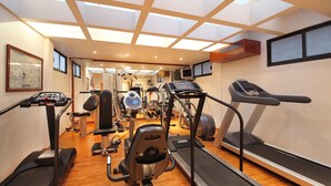 Un gimnasio con cintas de correr, elípticas y equipo de pesas.