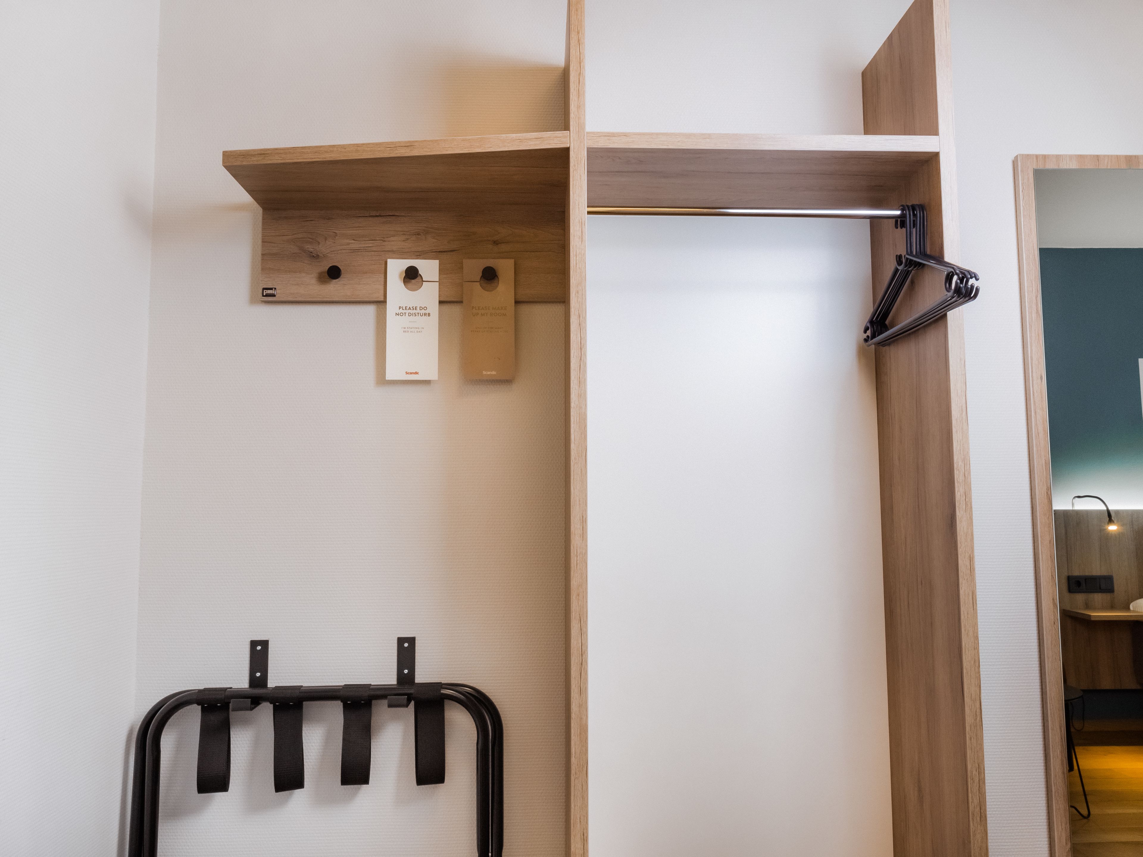 A wooden shelf with a hanging towel rack and a small sign.