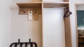 A wooden shelf with a hanging towel rack and a small sign.