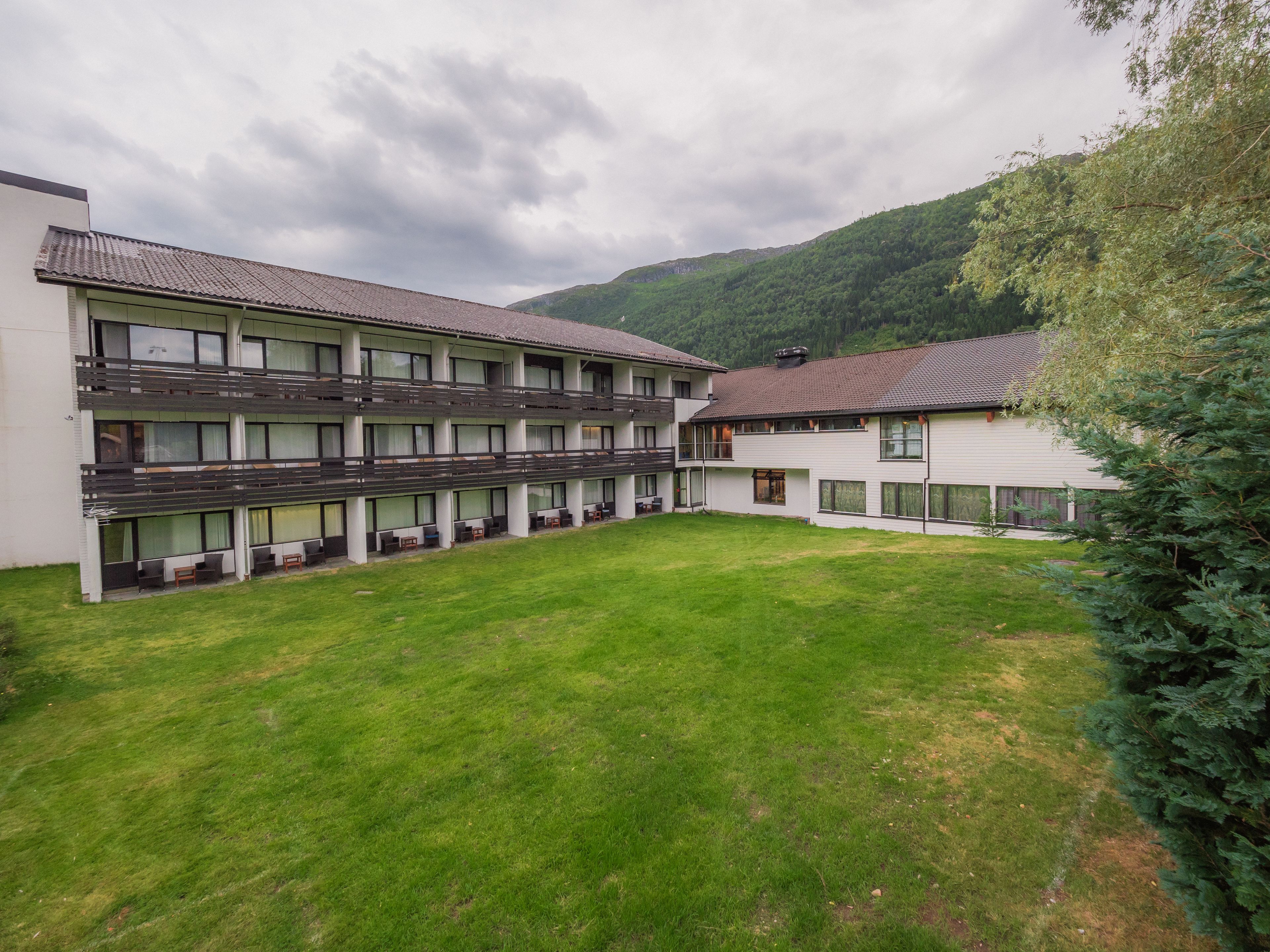 Un hotel de dos pisos con techo plano y un patio interior.