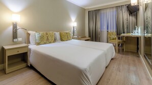 A hotel room with a large bed, bedside tables, a desk with a chair, and a mirror. - Olissippo Marques de Sa (Lisbon)