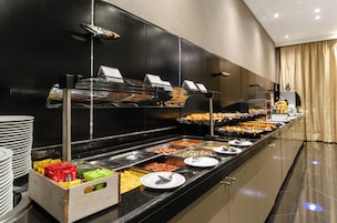 Um buffet com diversos pratos e acompanhamentos.