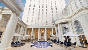 A large hotel with a central courtyard, a swimming pool, and outdoor seating areas. - Southern Sun The Cullinan (Cape Town)