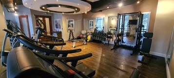 A gym with treadmills, dumbbells, and exercise balls.