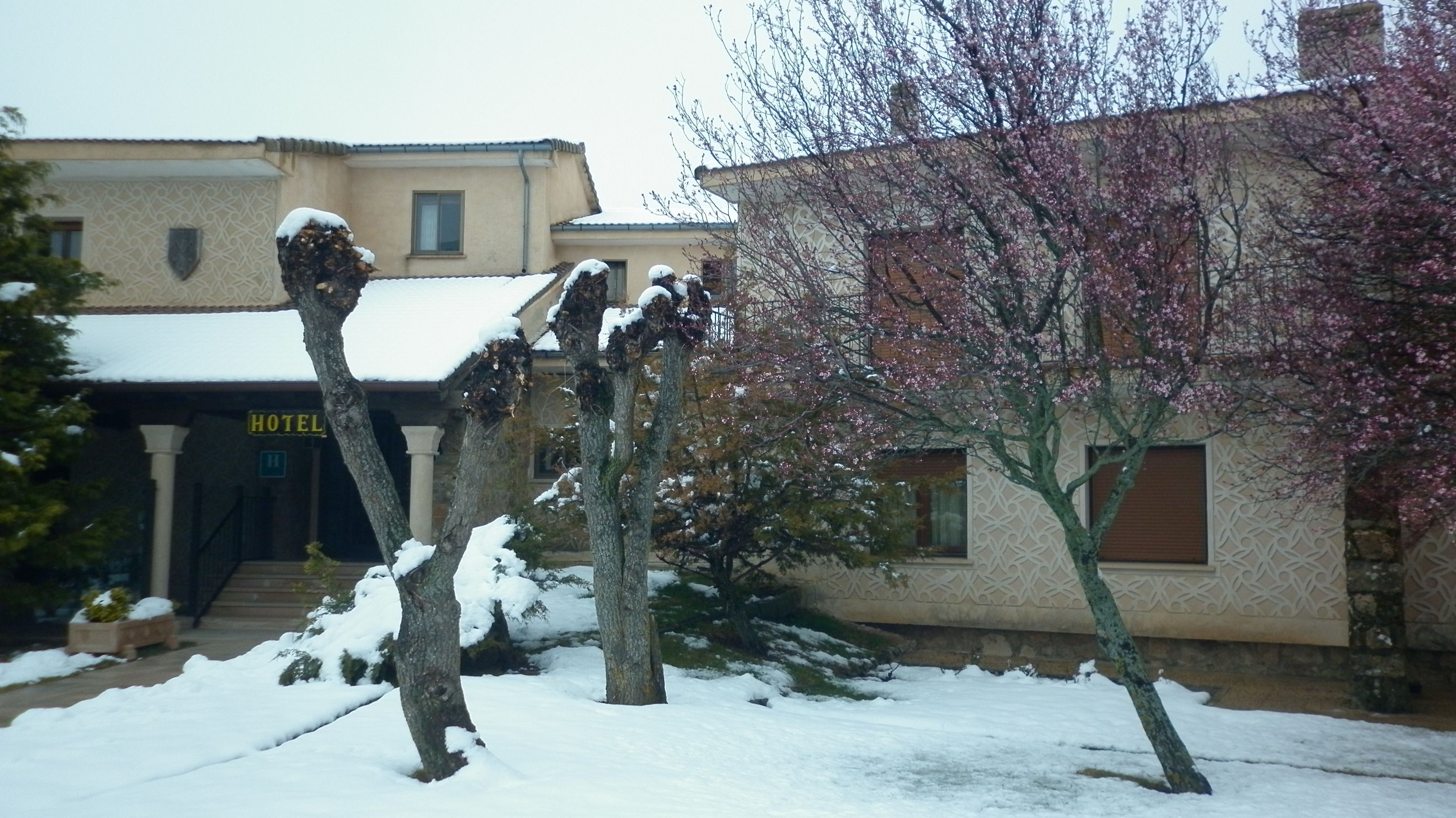 A hotel with a snow-covered exterior, a visible entrance, and a sign indicating the hotel's name.