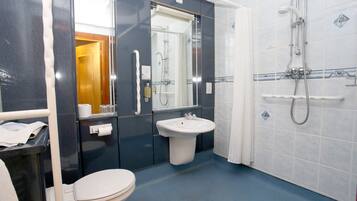 Une salle de bain avec des toilettes, un lavabo et une douche.