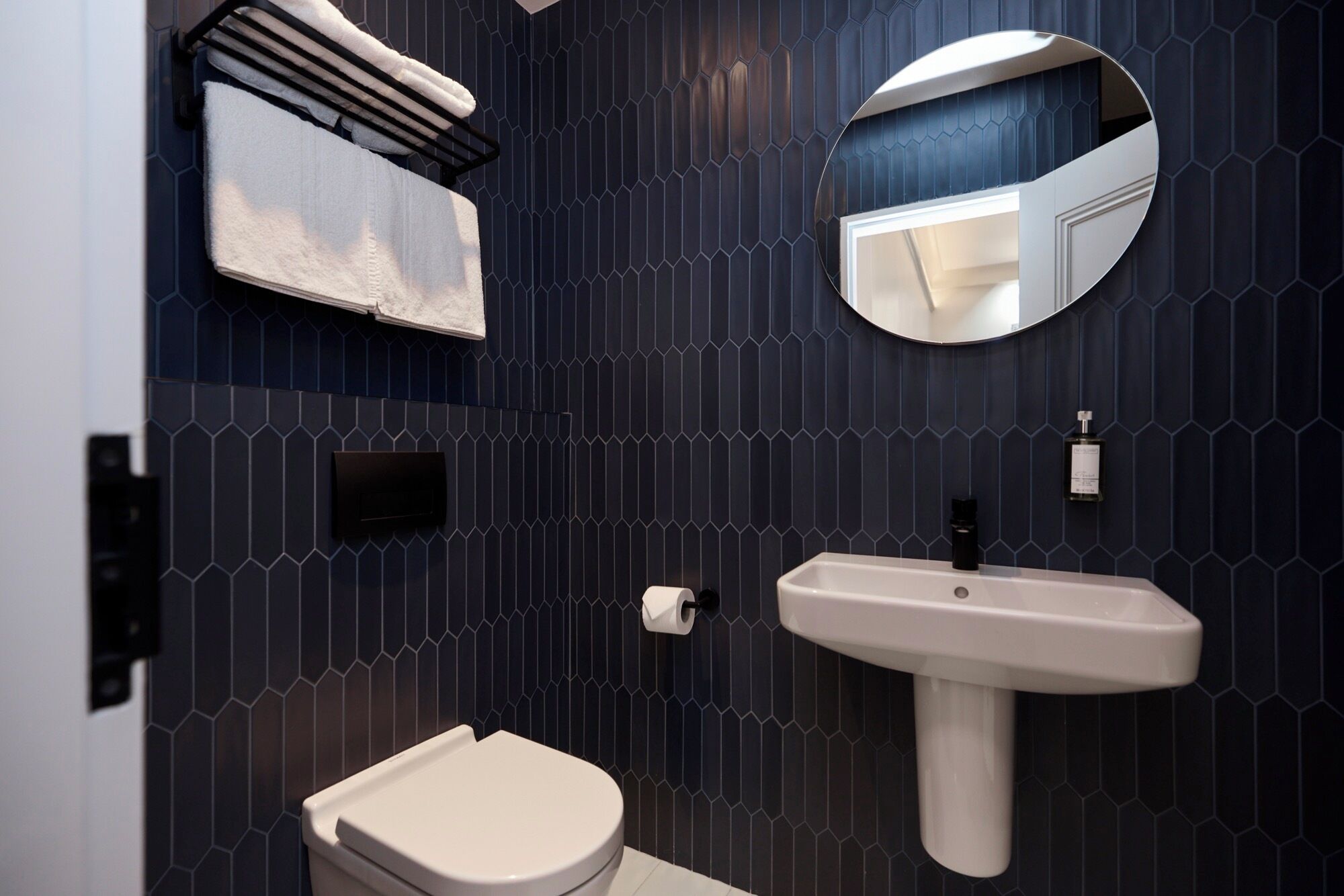 Ein modernes Badezimmer mit Toilette, Waschbecken und Handtuchhalter.