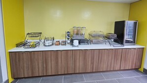A breakfast bar with various food items and a refrigerator. - Microtel Inn by Wyndham Atlanta Airport (College Park)