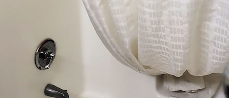 A white bathtub with a shower curtain.