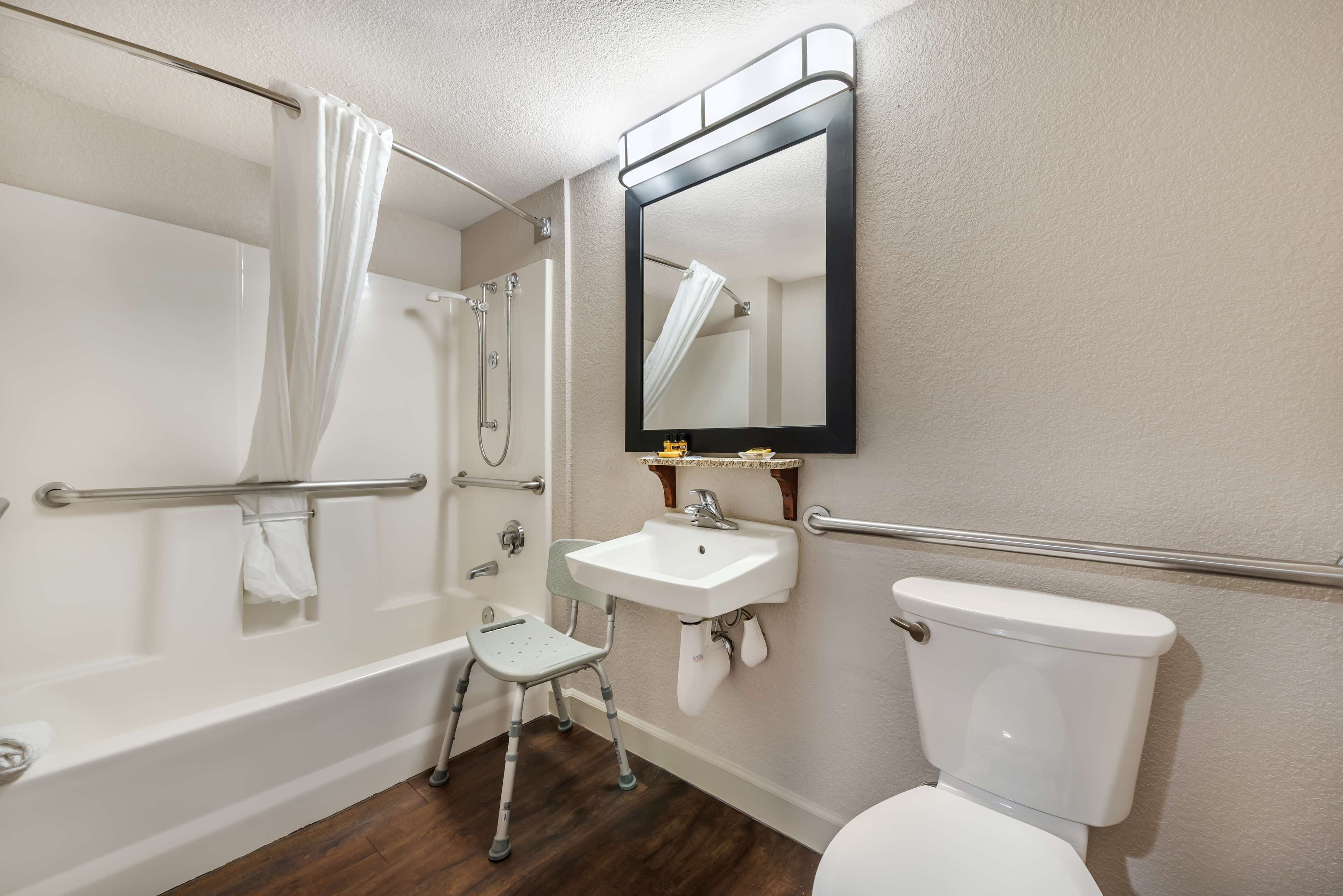 Une salle de bain avec une baignoire, un lavabo, des toilettes, un miroir et une douche.
