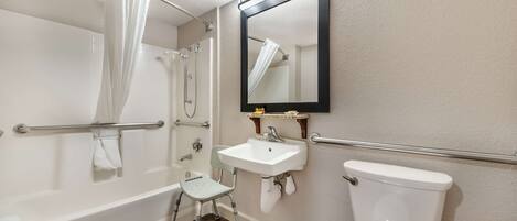 Une salle de bain avec une baignoire, un lavabo, des toilettes, un miroir et une douche.