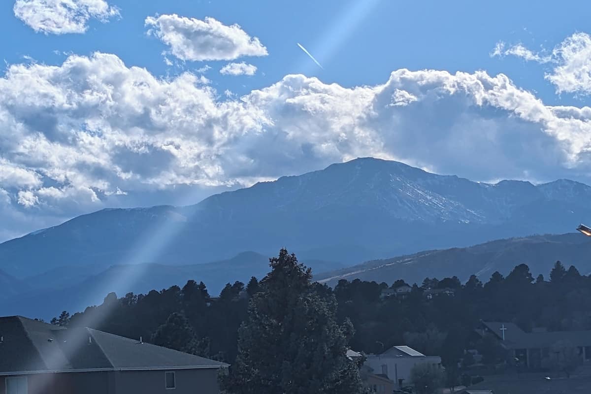 A mountain range with a clear sky and scattered clouds.