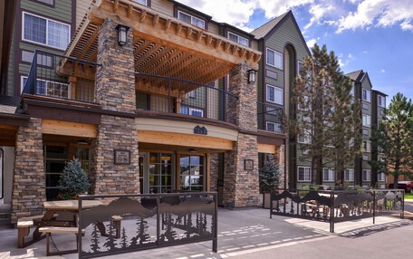 A multi-story building with a stone facade, wooden balcony, and a sign indicating a no smoking policy.