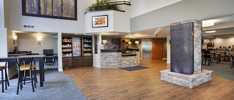 A spacious lobby with a reception desk, seating area, and a stone fireplace.