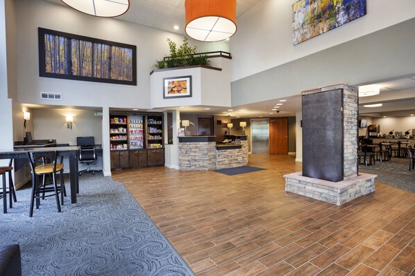A spacious lobby with a reception desk, seating area, and a stone fireplace.