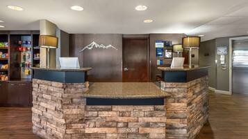 A reception area with a stone counter, two lamps, a door, and a wall-mounted sign.