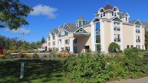 A multi-story hotel with a symmetrical facade, large windows, and a central entrance. - Bayside Hotel of Mackinac (Mackinaw City)
