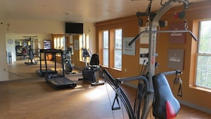 A gym with treadmills, elliptical machines, and a rowing machine. - Bayside Hotel of Mackinac (Mackinaw City)