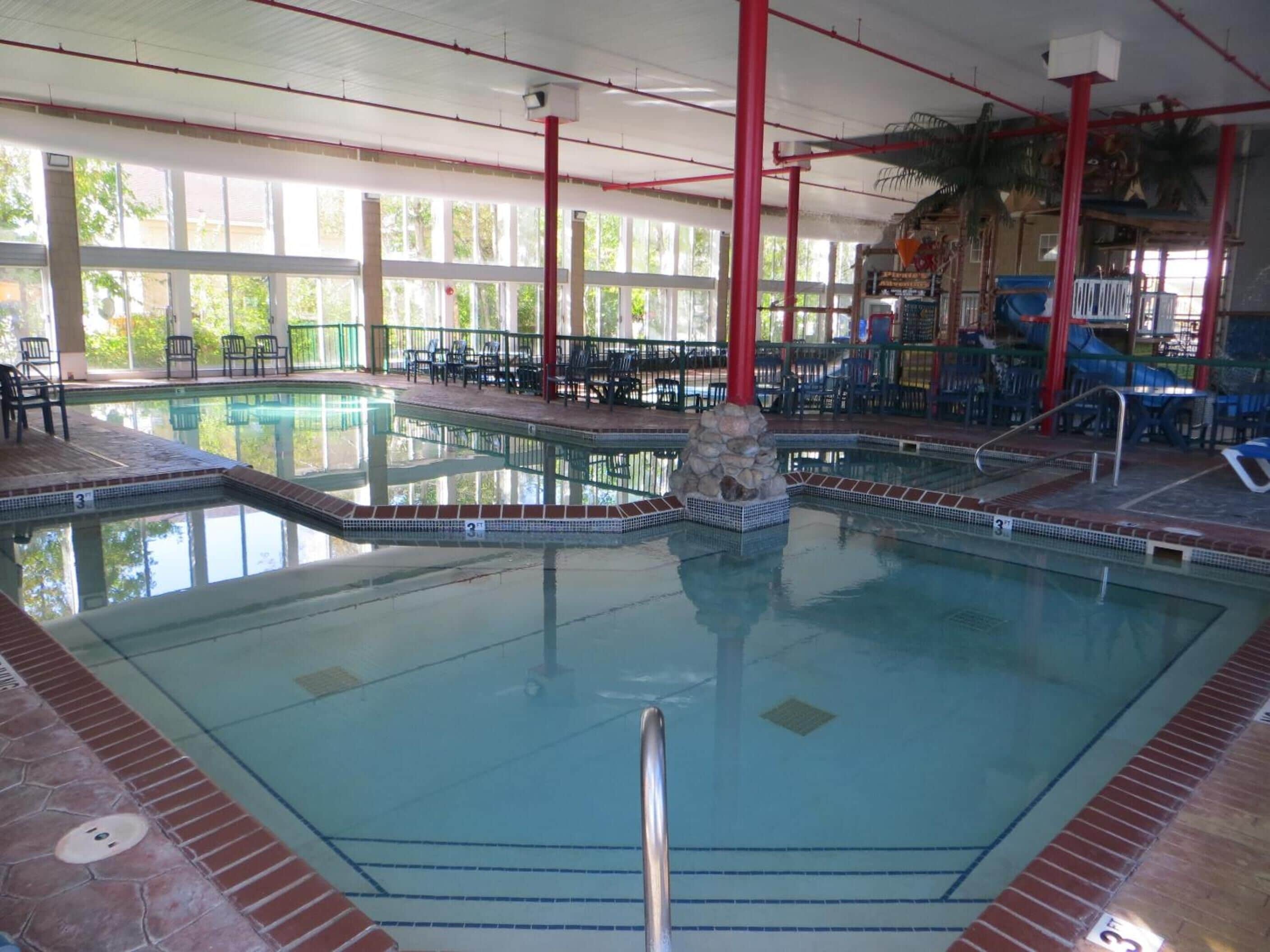 Una piscina techada, sillones reclinables de piscina