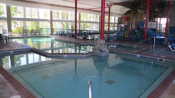 Una piscina techada, sillones reclinables de piscina