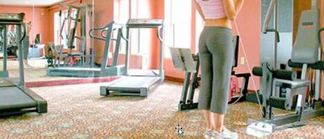 Un gimnasio con cintas de correr, elípticas y equipos de pesas.