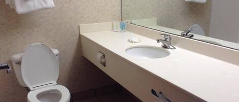 A bathroom with a toilet, sink, and towel rack.