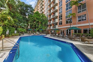 Una piscina al aire libre, tumbonas