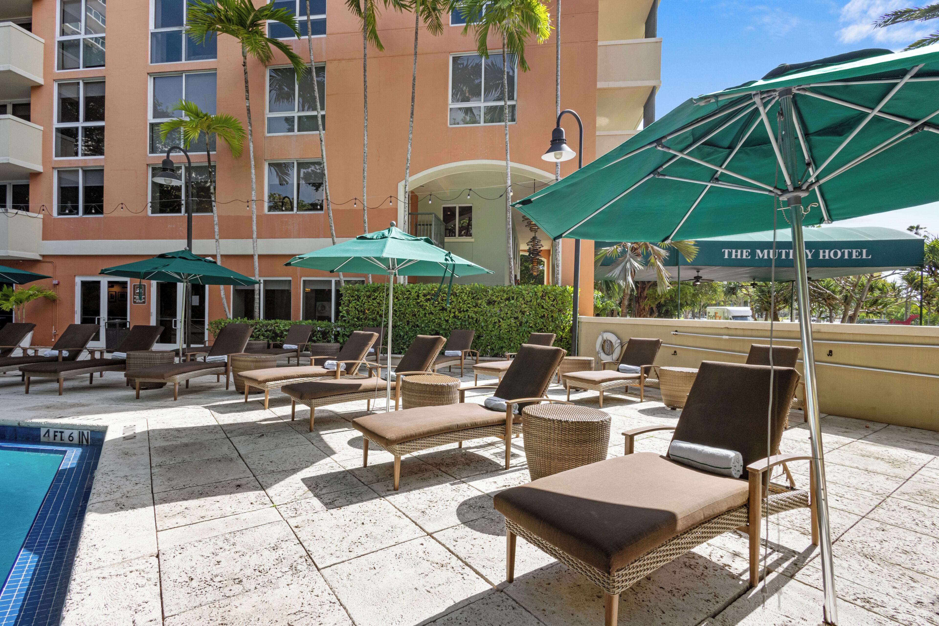 A poolside area with lounge chairs and umbrellas at The Mutiny Hotel.