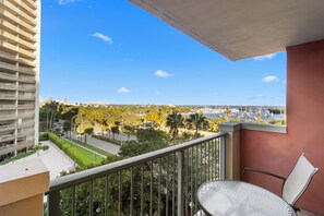 Un balcón con vistas despejadas de un paisaje urbano, que incluye edificios y un puerto deportivo.