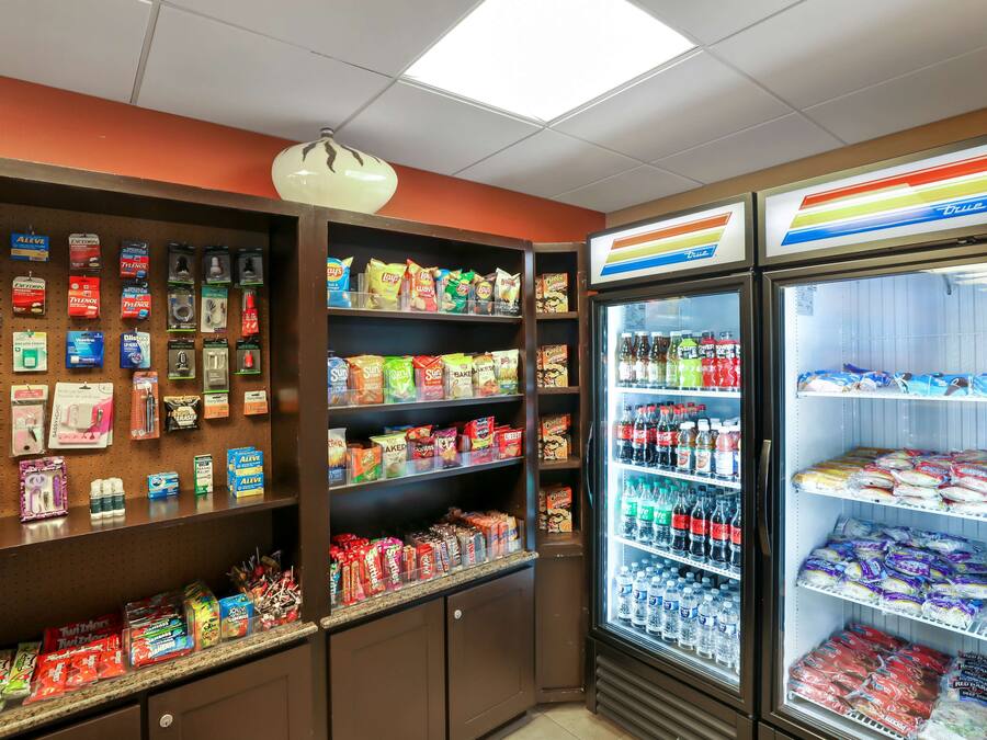 A snack and beverage display area with various packaged snacks, chips, and bottled drinks.