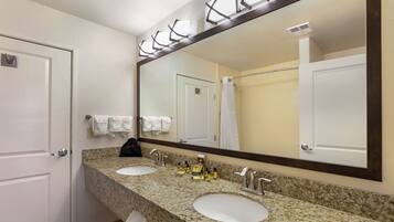 A bathroom with two sinks, a large mirror, and a towel rack.