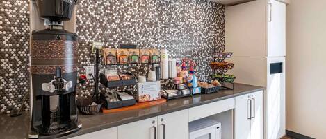 A kitchenette with a coffee machine, coffee pods, and a microwave.