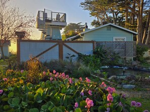A residential property with a fenced yard, a small pond, and flowering plants. - The Inn at Schoolhouse Creek (Little River)