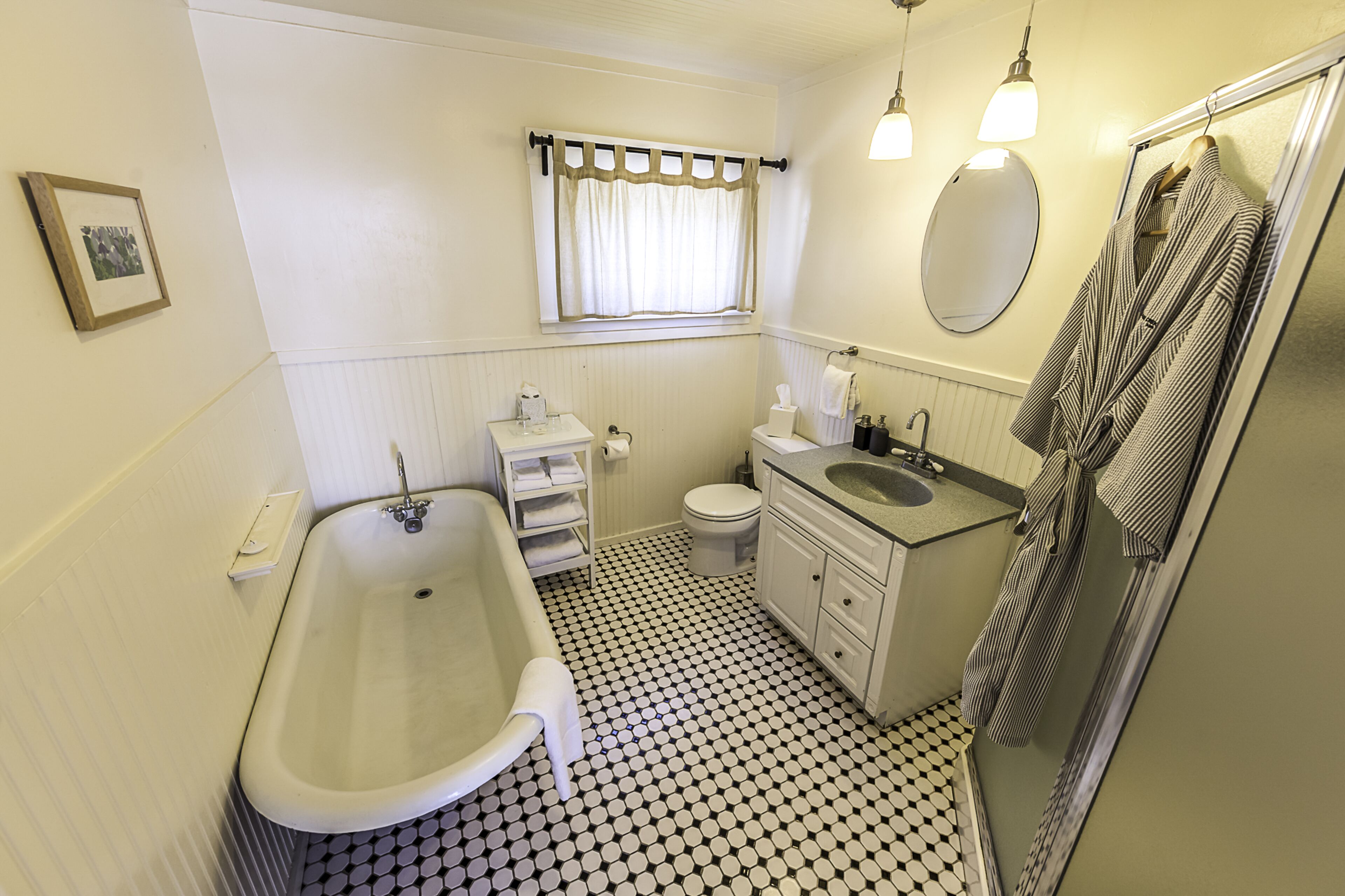 A bathroom with a bathtub, toilet, sink, and a mirror.