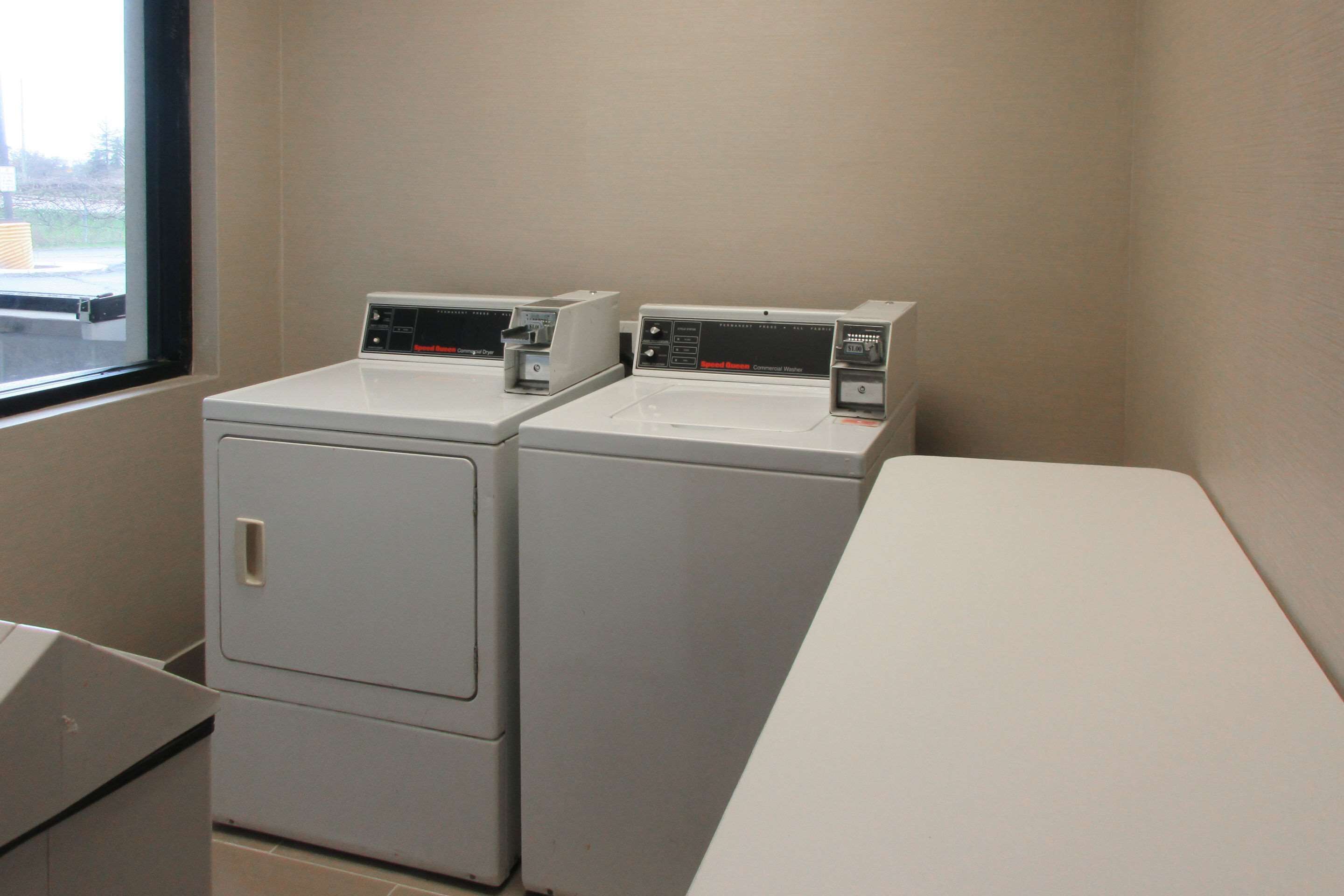 Un espace buanderie équipé de deux machines à laver à chargement frontal et d’une table blanche.
