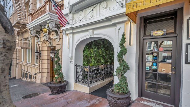 A building entrance with an American flag, a cafe espresso sign, and a door with a window.