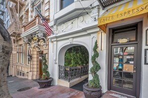 A building entrance with an American flag, a cafe espresso sign, and a door with a window. - Nob Hill Hotel (San Francisco)