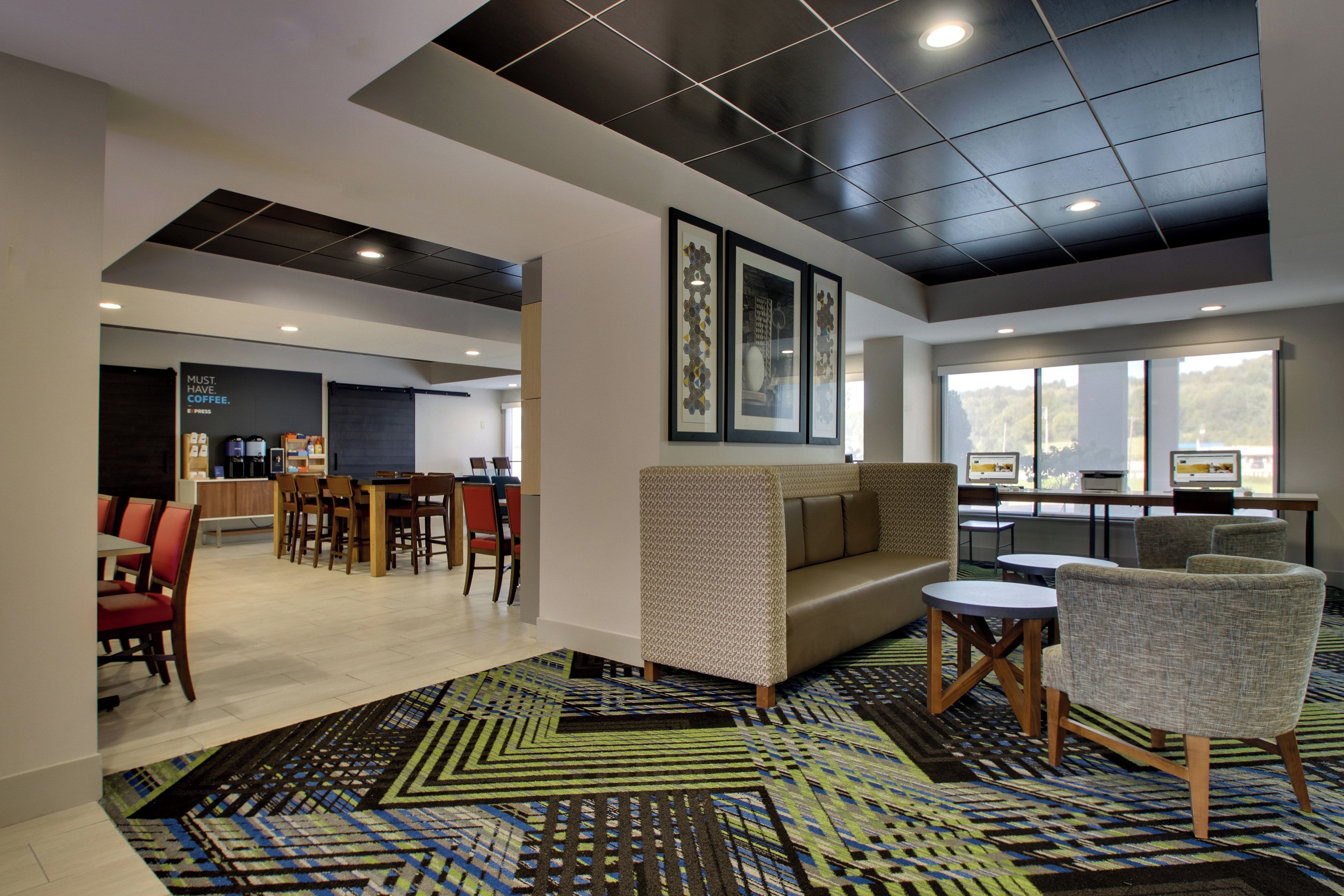 Um hall de hotel com área de refeições, assentos e obras de arte nas paredes.