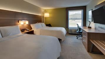 Une chambre d’hôtel avec deux lits, un bureau, une chaise, une télévision et une fenêtre donnant sur un paysage agréable.