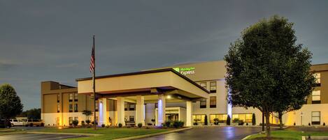 A Holiday Inn Express building with a flat roof, large windows, and a flagpole.