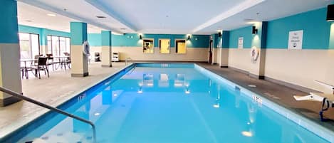 An indoor swimming pool with clear water, marked depth indicators, and a 'No Diving Allowed' sign.