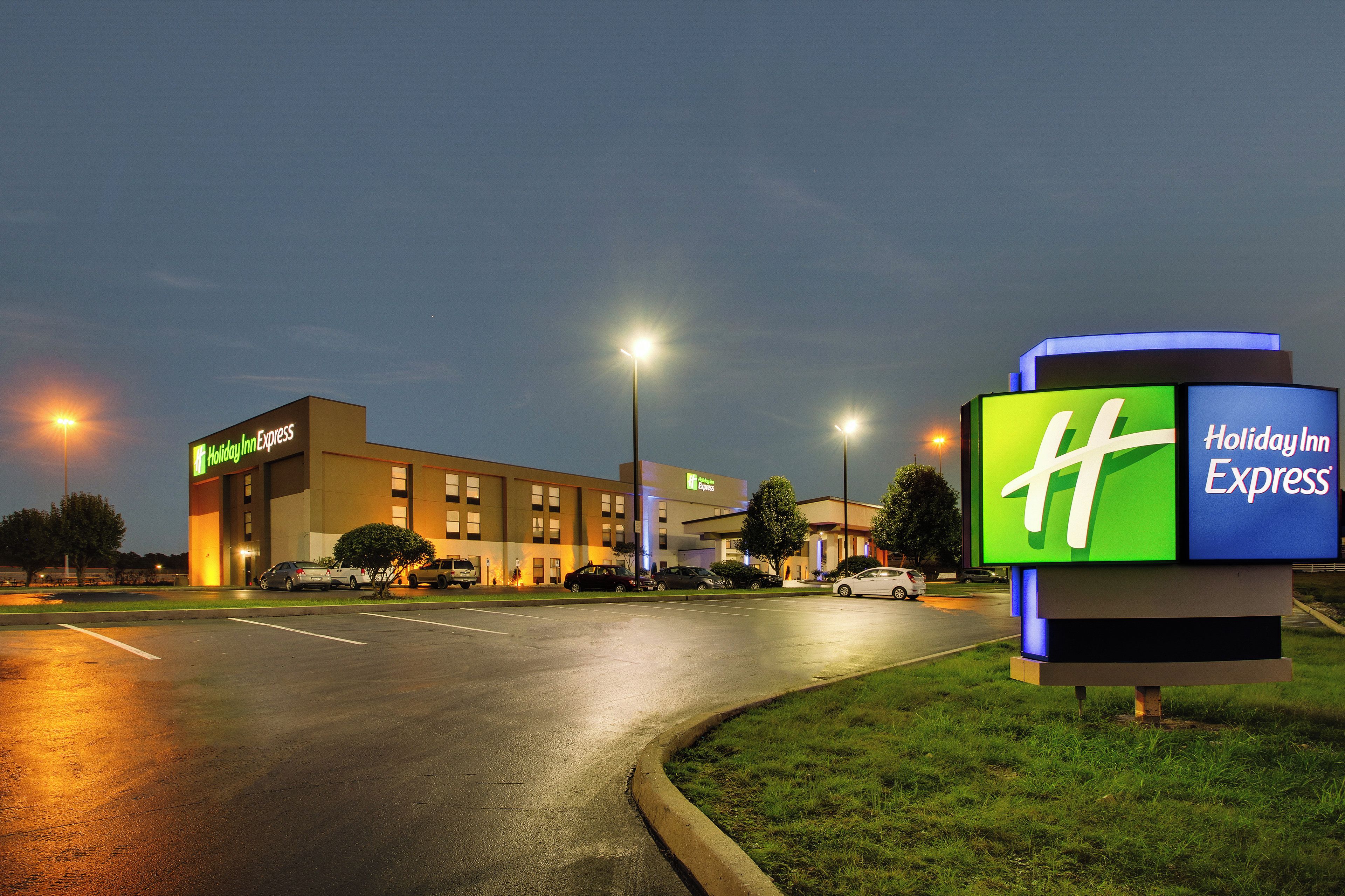 A Holiday Inn Express hotel with a parking lot and street view at night.